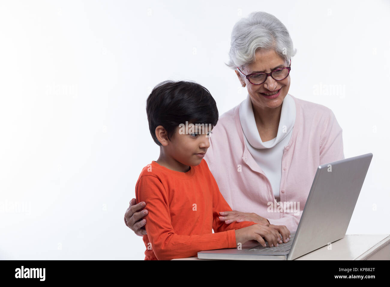 Nonna e nipote seduti insieme utilizzando il computer portatile Foto Stock