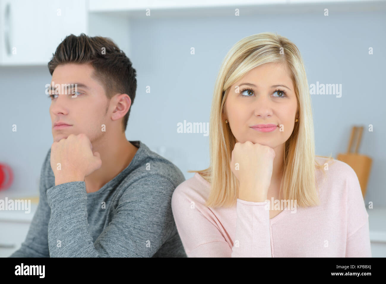 Uomo e donna con loro i menti sulle loro mani Foto Stock