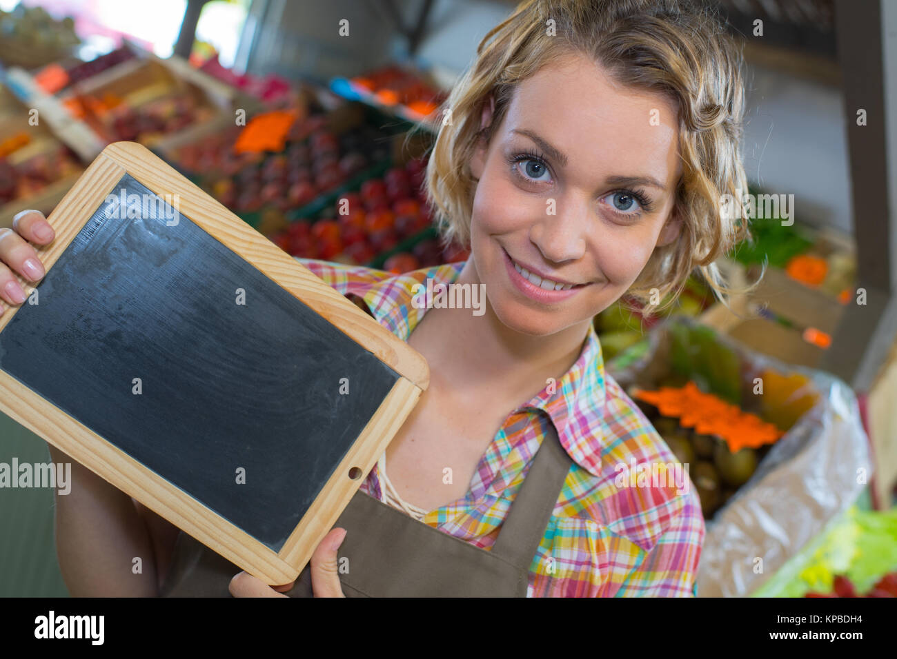 Sorridente personale femminile tenendo la scheda nel supermercato Foto Stock