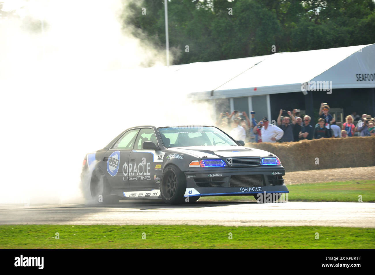 Una macchina di eseguire un burn out al 2017 Goodwood Festival della velocità. Foto Stock