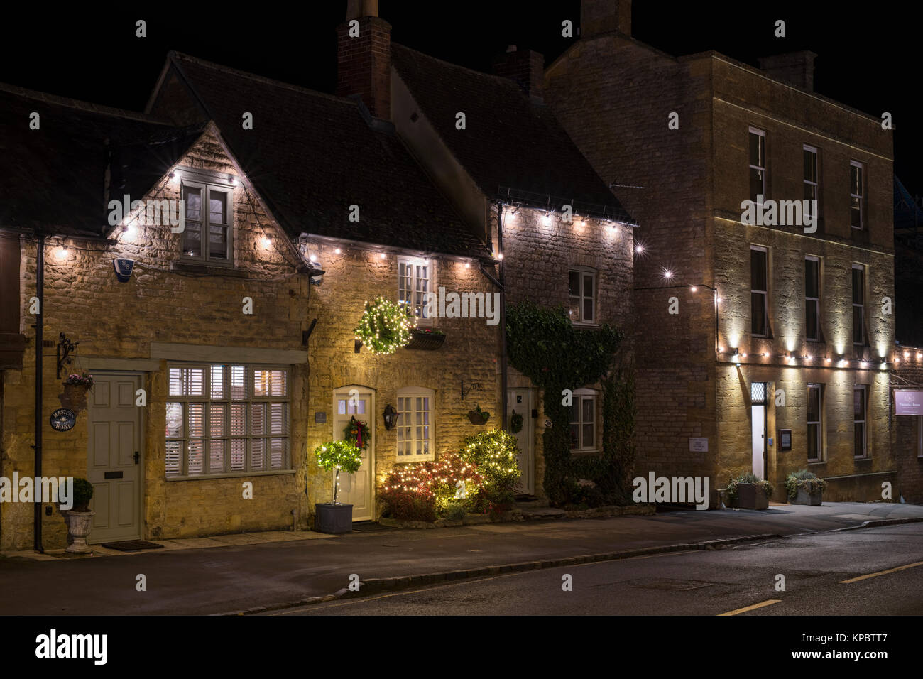 Sheep Street case con decorazioni di Natale di notte. Stow on the Wold, Cotswolds, Gloucestershire, Inghilterra Foto Stock