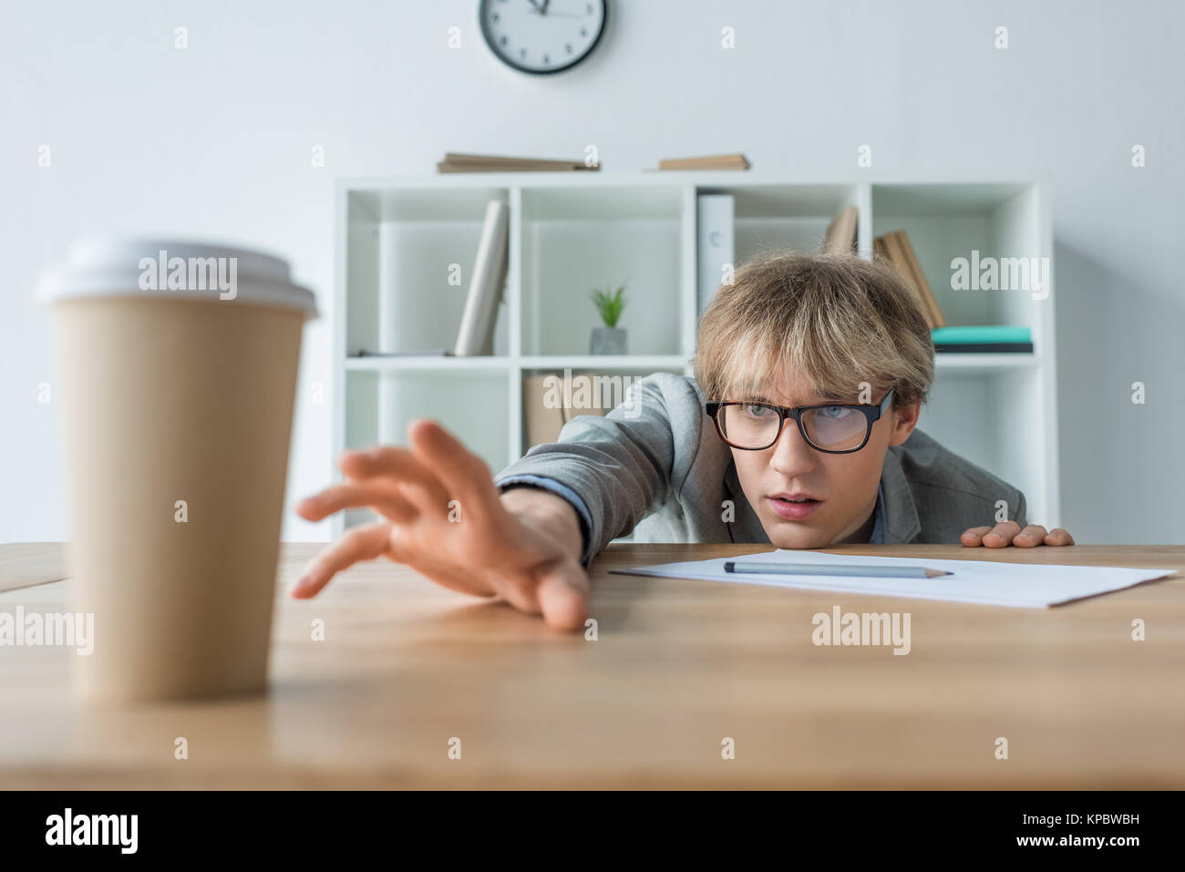 Imprenditore per raggiungere il caffè nel bicchiere di carta Foto Stock