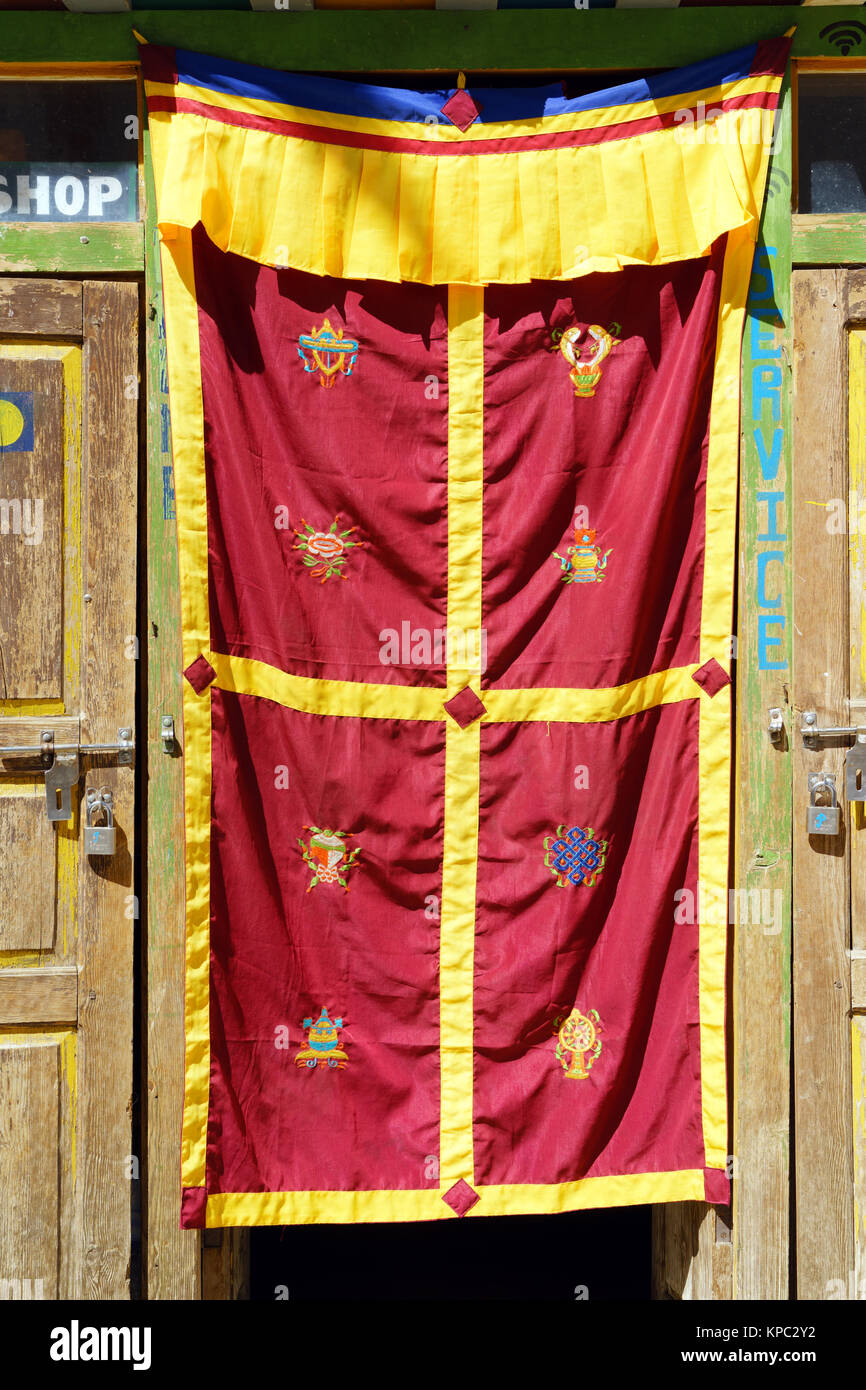 La tendina della porta con il 8 di buon auspicio Buddista Tibetana simboli, Lo Mantang, Mustang Superiore regione, Nepal. Foto Stock