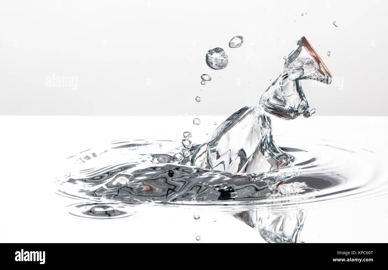 Coin splash in acqua catturati con fotografie ad alta velocità, su sfondo bianco Foto Stock