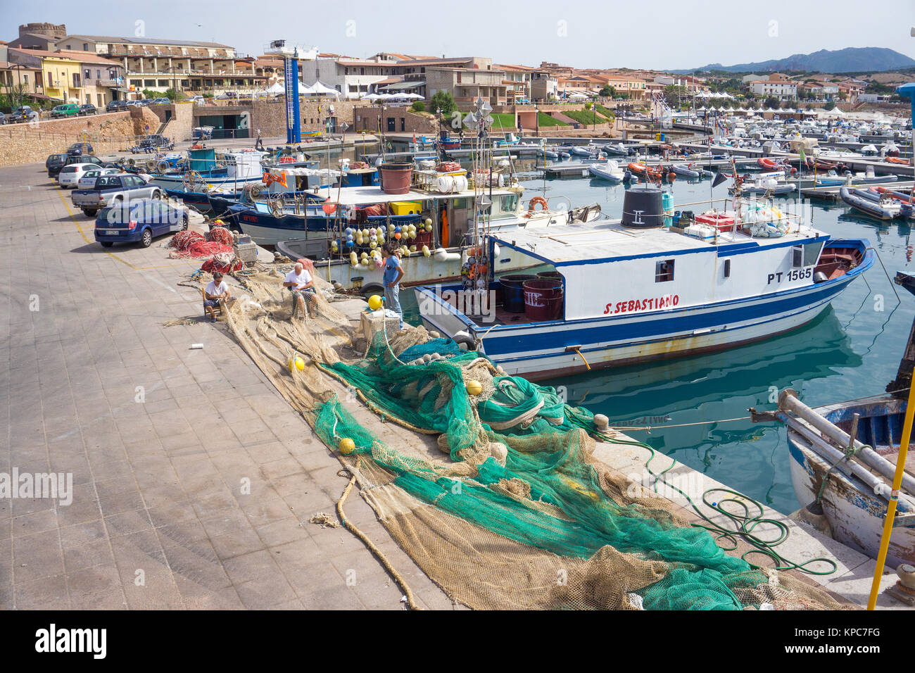 I pescatori riparare reti presso il porto di Isola Rossa, Olbia-Tempio, Sardegna, Italia, mare Mediterraneo, Europa Foto Stock