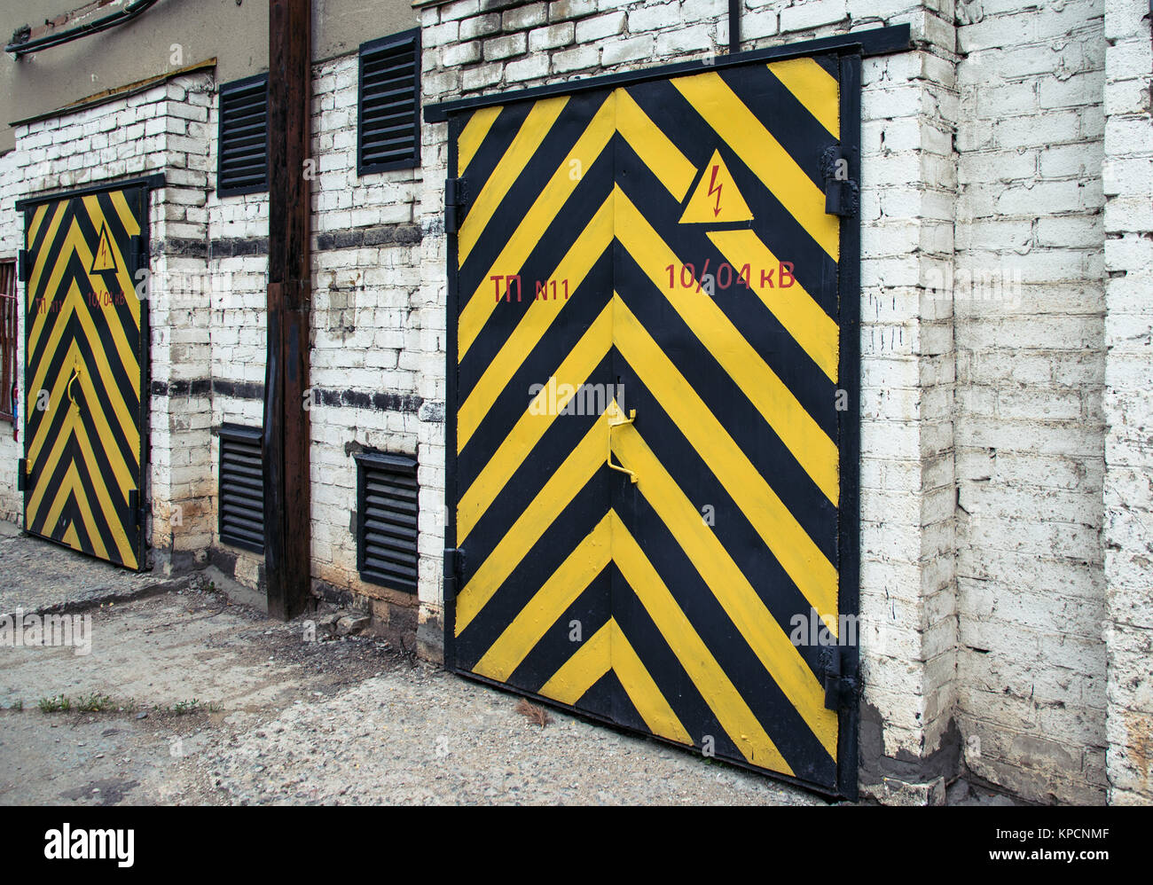 Vecchia porta di legno di colore giallo e con una striscia nera Foto Stock