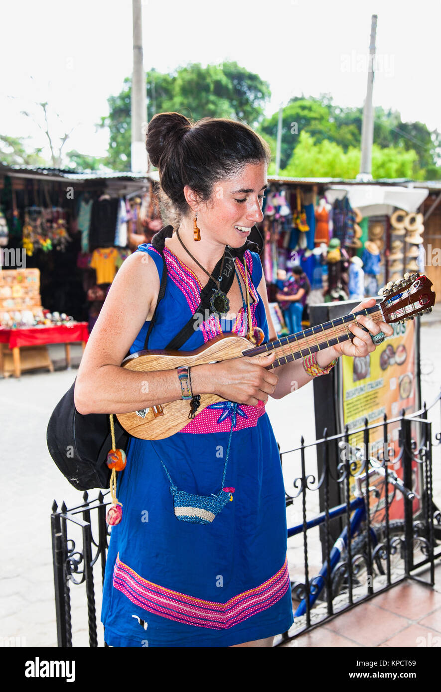 ANTIGUA, GUATEMALA -DEC 24, 2015: giovane bella donna a suonare la chitarra in strada di Antigua su Dec 24, 2015. Guatemala. Foto Stock