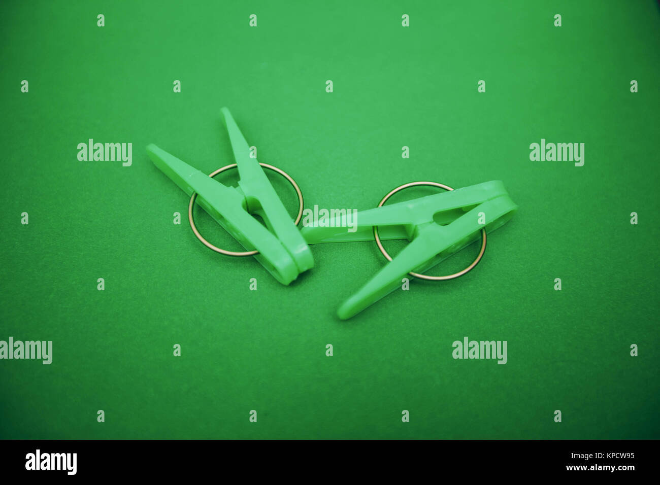Plastica verde abiti abiti da pioli su un luminoso di un colore di sfondo verde. Vista dall'alto. Materiali di consumo per uso domestico isolato. vista dall'alto. Close up Foto Stock