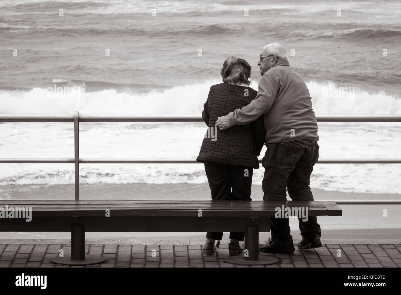 Vista posteriore della coppia di anziani che guarda al mare. Foto Stock