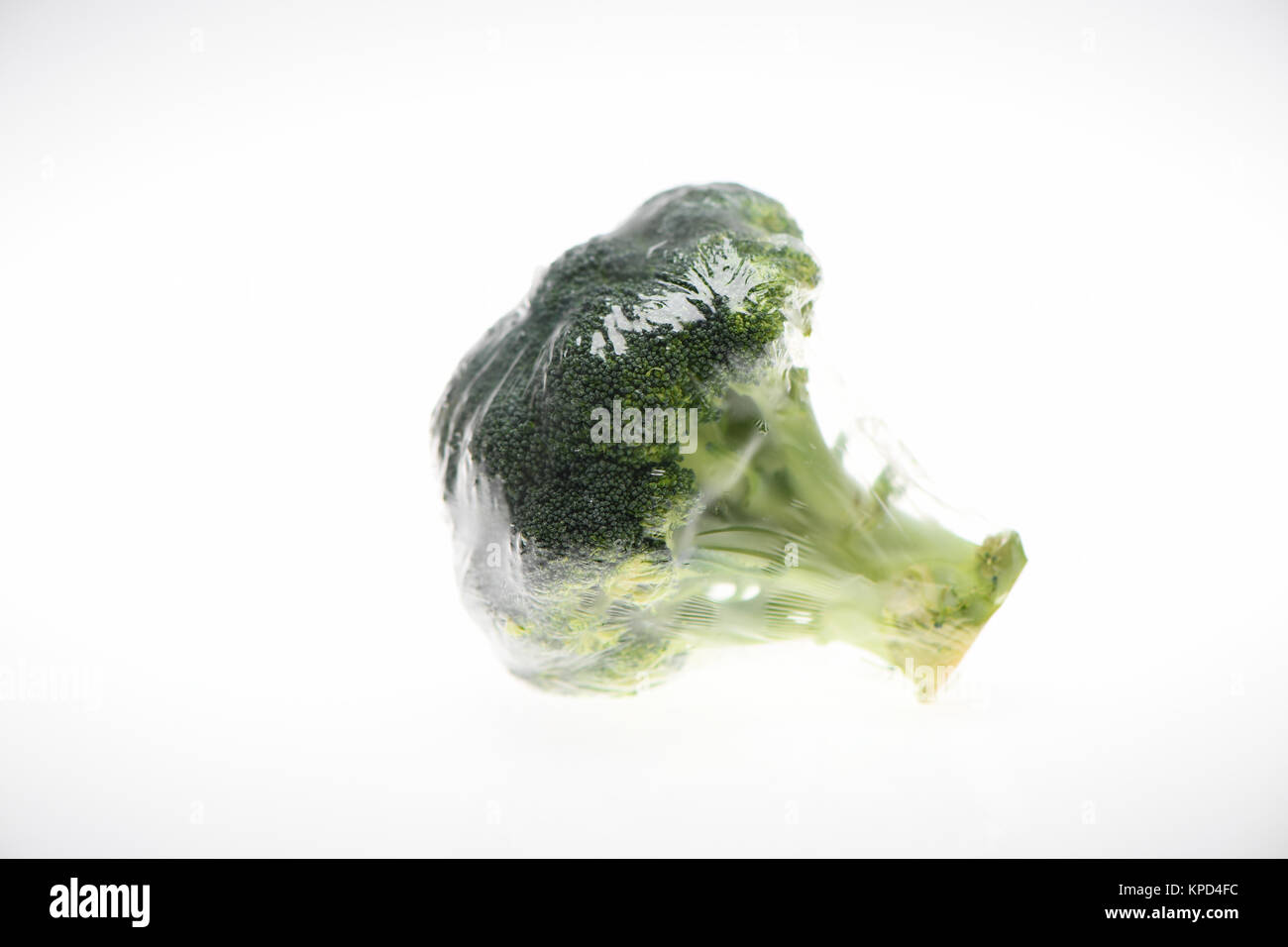 Cibi avvolti in plastica pellicola , visto qui è broccoli su uno sfondo bianco preparate per la vendita in un supermercato. Foto Stock