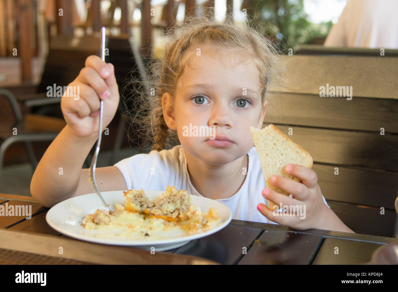 Quattro anni di ragazza ha pranzo presso un cafe' all'aperto Foto Stock