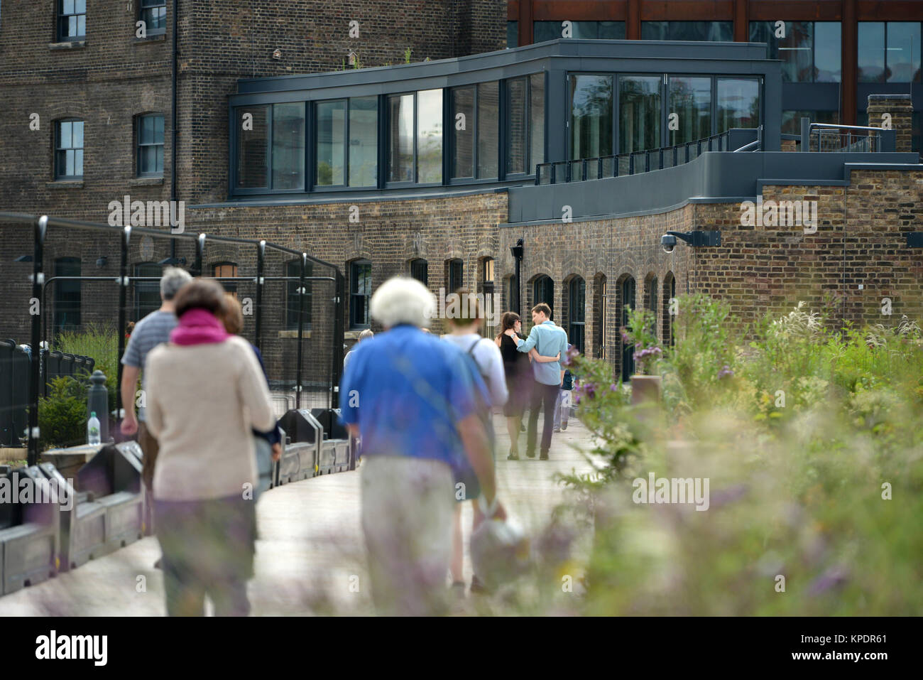 La gente camminare lungo il ristrutturato Regent's Canal Alzaia, Kings Cross, London. Foto Stock
