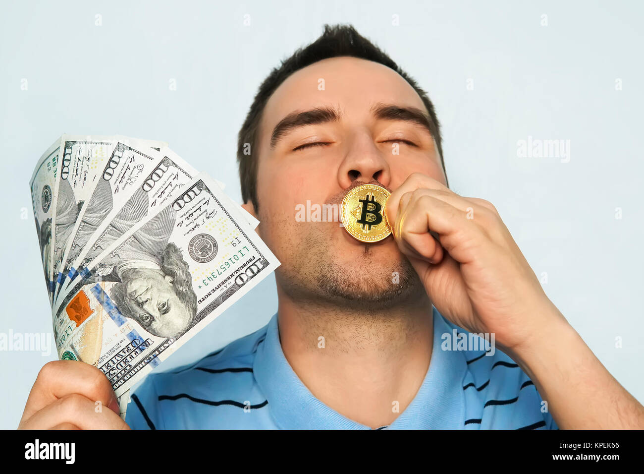 Guy bacia la medaglia d'oro pieno di gioia bitcoin da vincere in borsa. Il profitto dal tasso di crescita di mining bitcoin e guadagnare bitcoin. home Foto Stock