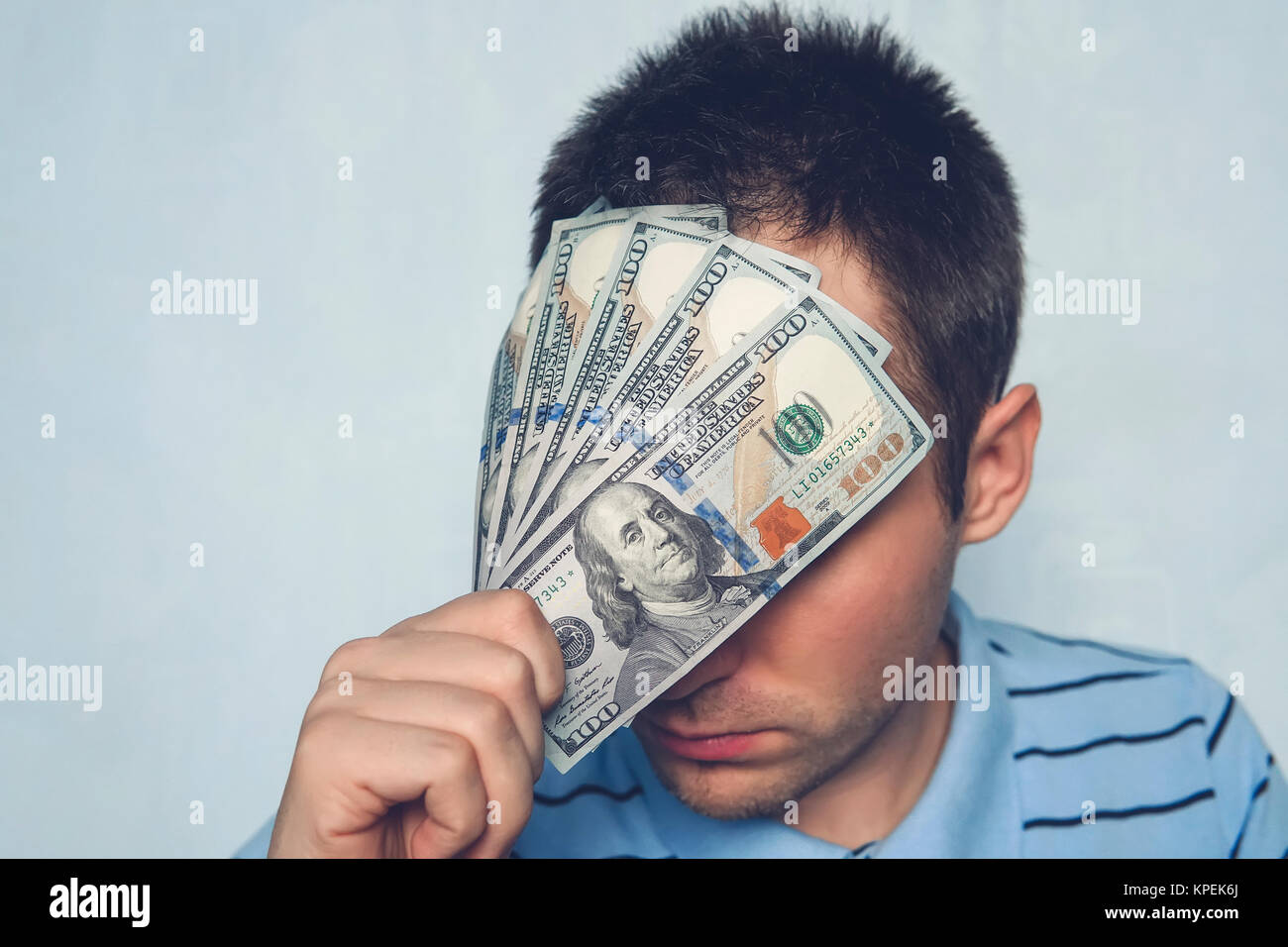 Il ragazzo può contenere fino a un 500 dollari bill davanti ai miei occhi. vedere attraverso denaro. nascondersi dietro il denaro. coprire i suoi occhi per un regalo. Foto Stock