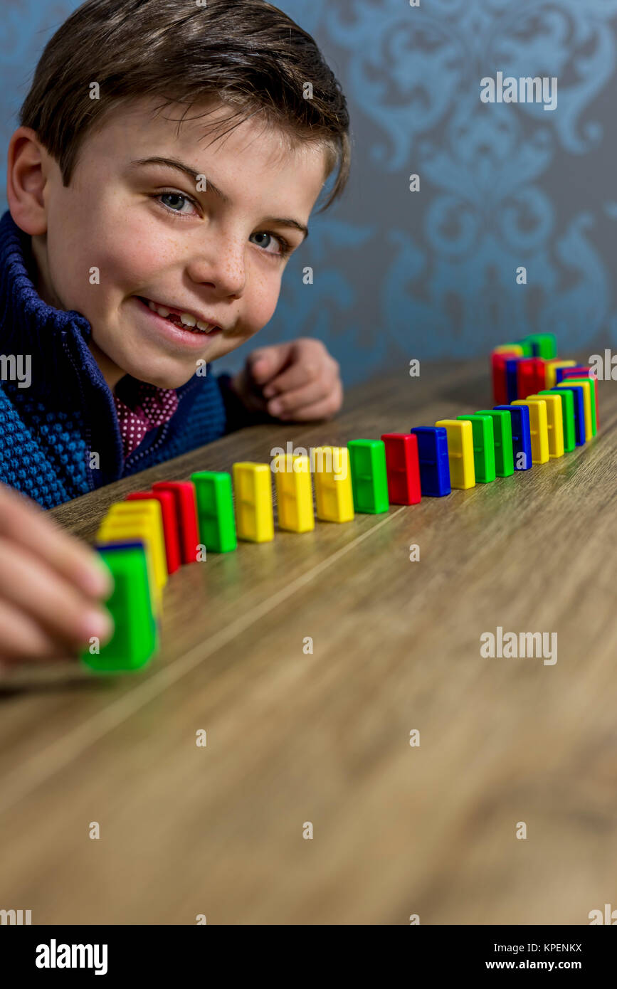 Ragazzo giocando con domino Foto Stock