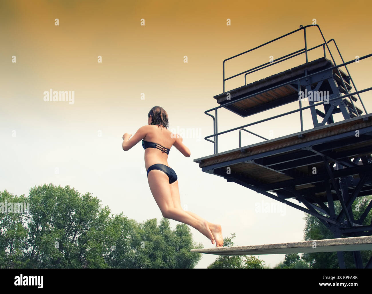 La ragazza che salta da un trampolino di lancio Foto Stock