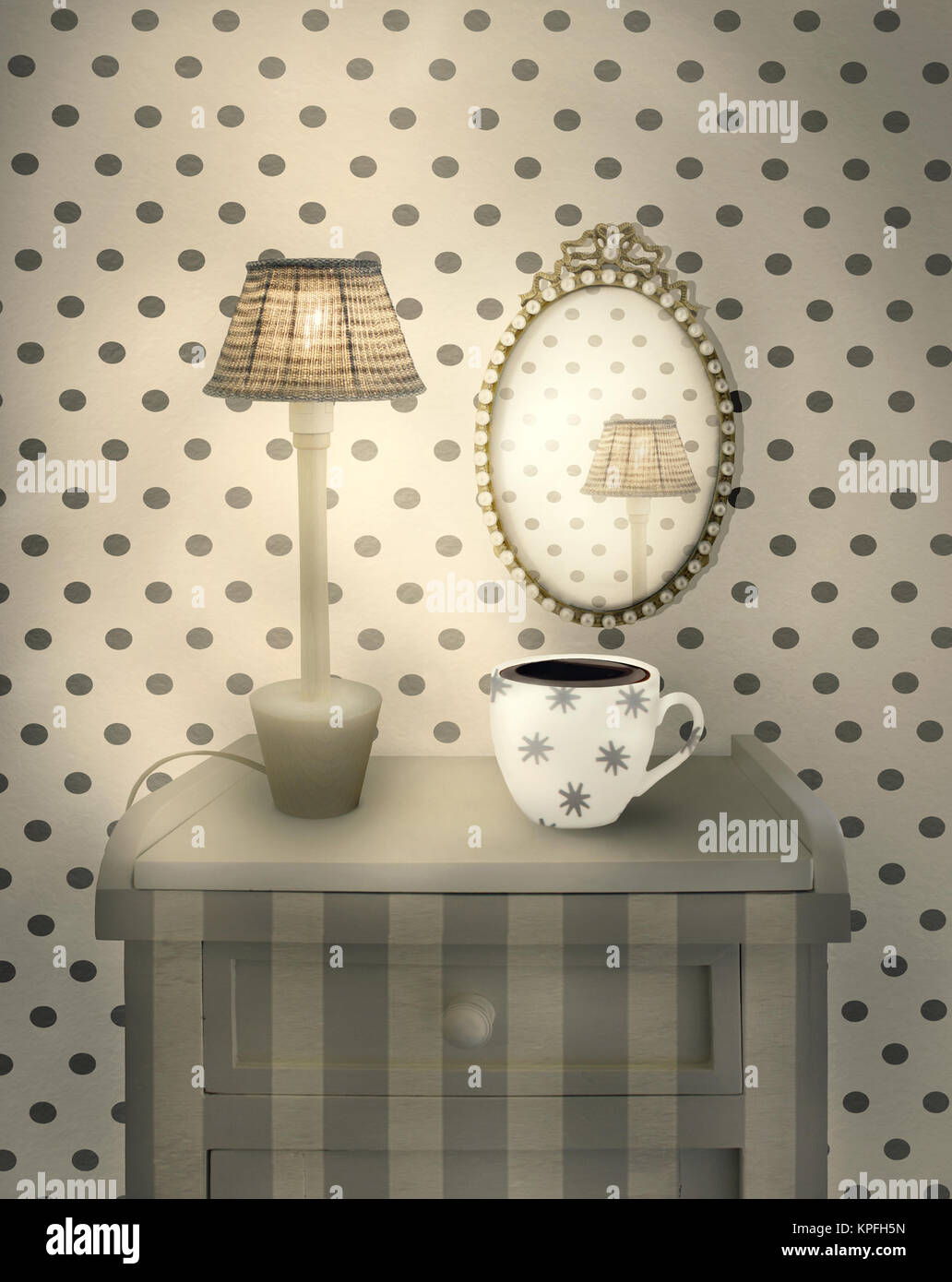 Bellissimi interni dettaglio di un comodino con lampada accesa una tazza e un specchio ovale in un ambiente accogliente Foto Stock