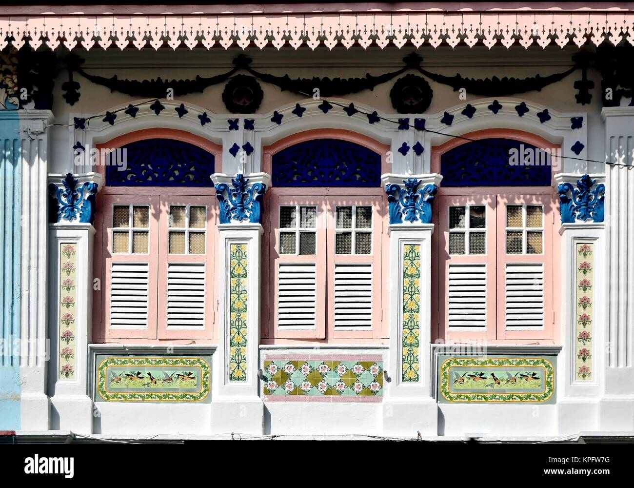 Classico Cinese Singapore negozio Casa con finestre ad arco, rosa persiane di legno e lavori ornamentali in pietra nel centro storico di Little India Foto Stock