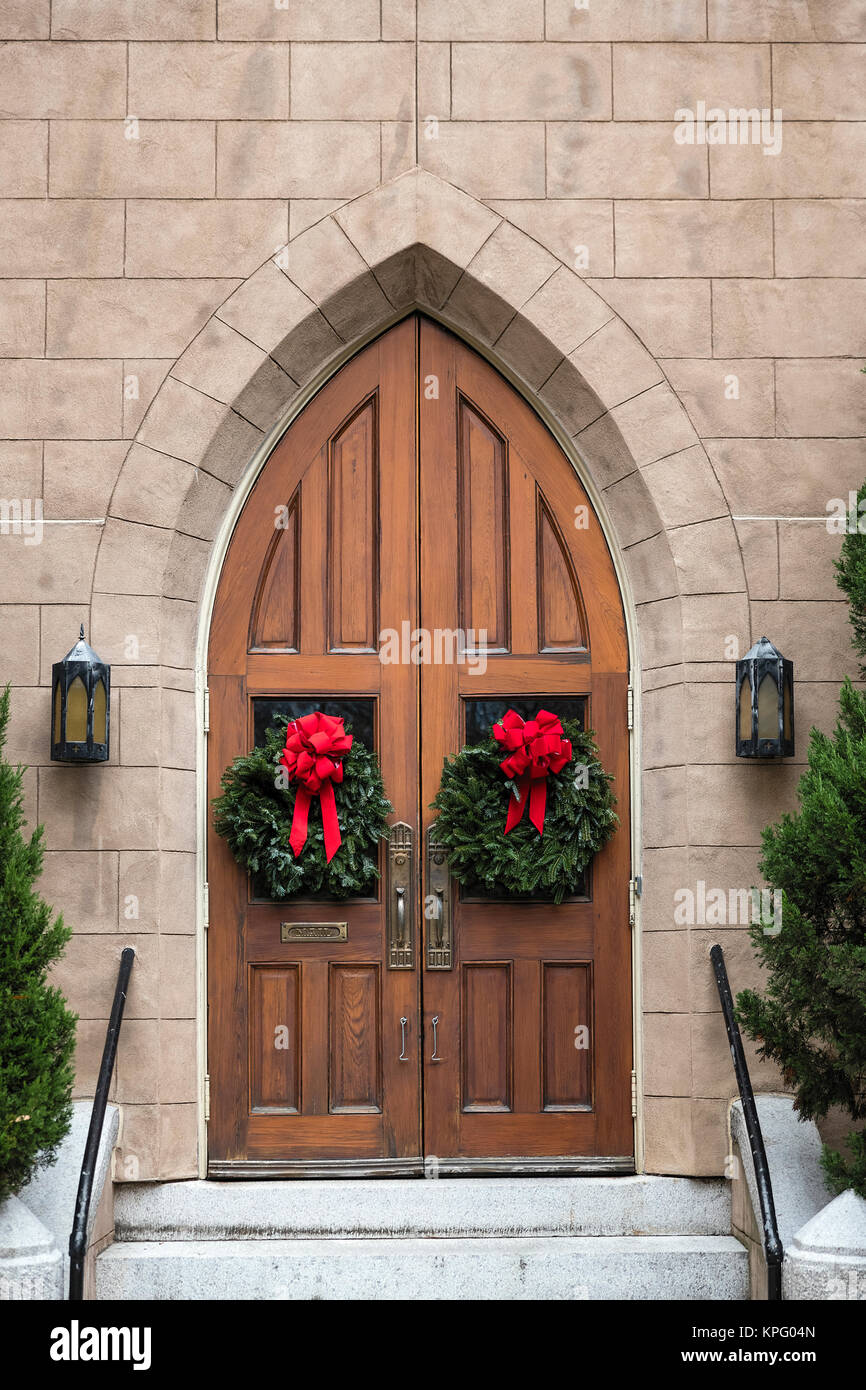 Ghirlande di Natale sulla suggestiva chiesa porta. Foto Stock