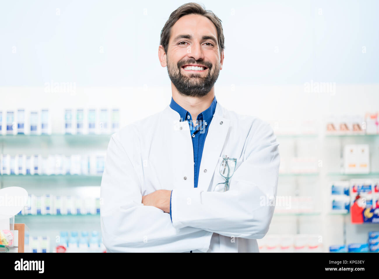 Il farmacista in farmacia è rivolta verso il ripiano con farmaci Foto Stock