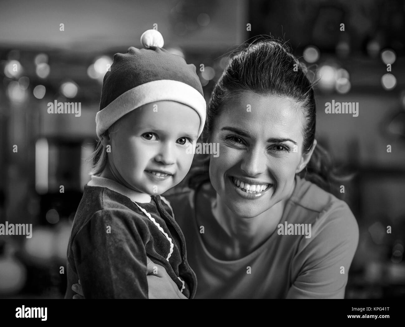Ritratto di sorridere il bambino e la madre nel Natale decorato cucina Foto Stock
