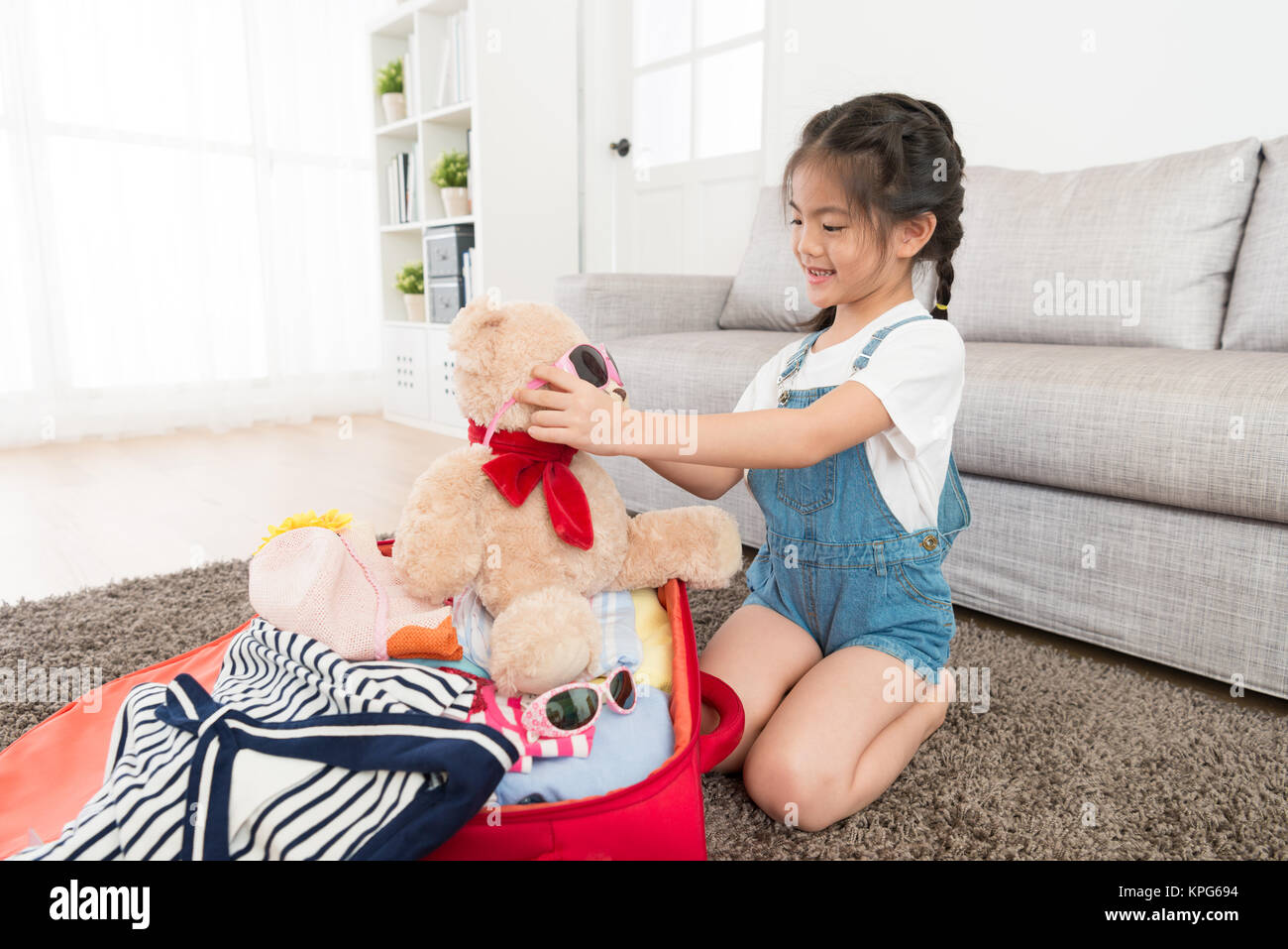 Piuttosto sorridente bambina bagagli imballaggio valigia in ... Piuttosto sorridente bambina bagagli imballaggio valigia in ...