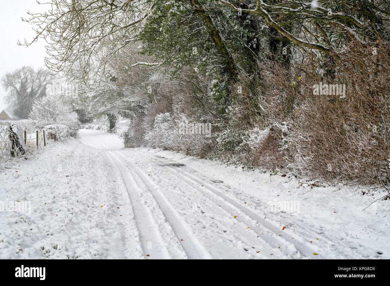 Coperta di neve country road vicino a Lower Slaughter in dicembre. Lower Slaughter, Cotswolds, Gloucestershire, Inghilterra Foto Stock