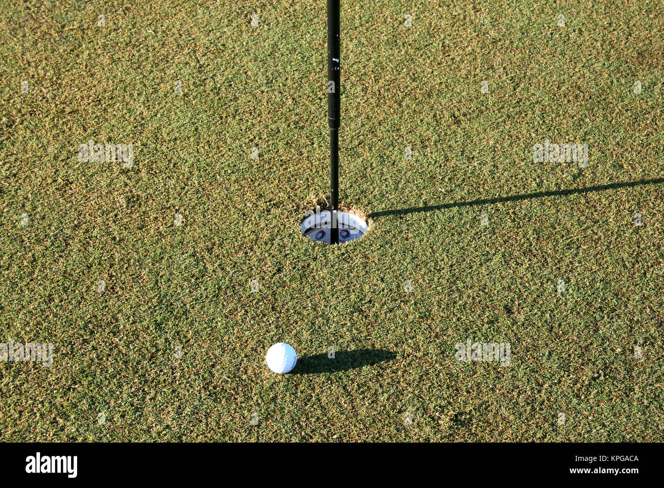 La pallina da golf con flagstick nel foro sul putting green, White River - Mpumalanga Foto Stock