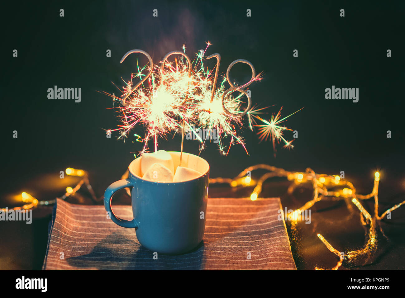2018 forma infiammando Sparkler in tazza con Marshmallows sul tavolo per esterno Foto Stock