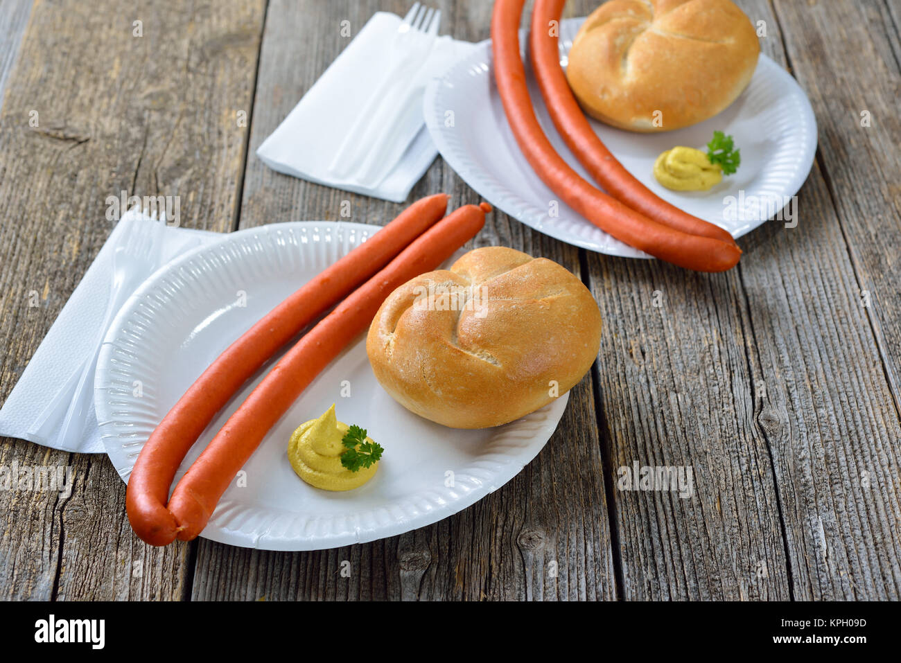 Il tedesco street food: Hot Debreziner salsicce con senape piccante e un nuovo rullo su un piatto di carta Foto Stock