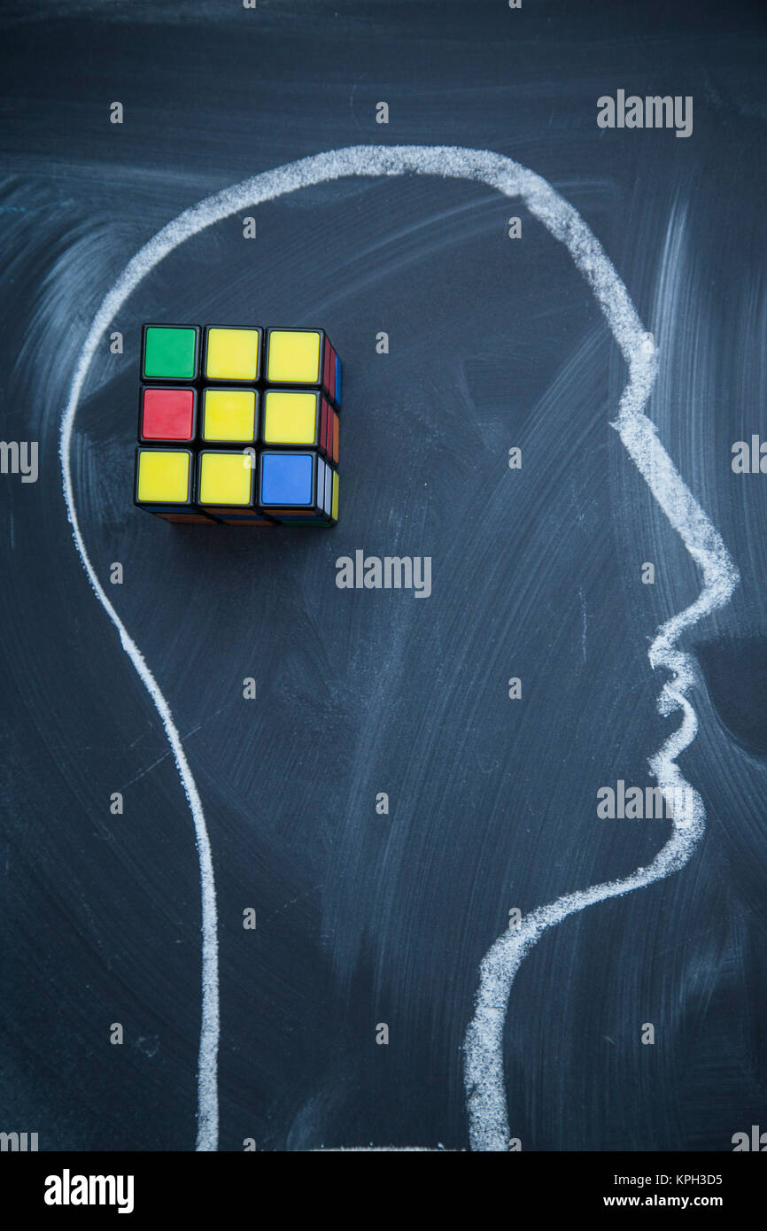 Il pensiero creativo. Una testa disegnati con un gesso su una lavagna e un cubo di Rubik. Lo spazio per il tuo testo o produst display. Foto Stock