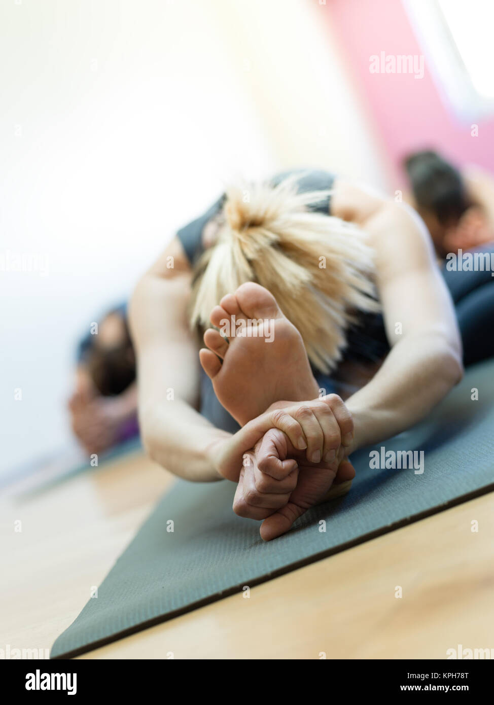 Donna facendo esercizio fisico e stretching gambe su un tappetino, piede close up, uno stile di vita sano concetto Foto Stock