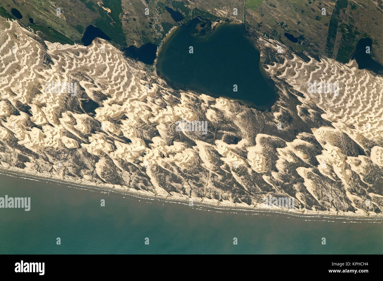 Un astronauta a bordo della Stazione Spaziale Internazionale catturato questa fotografia di Lagoa dos Barros e a forma di mezzaluna dune barchan sul litorale Atlantico del sud del Brasile. Lagoa dos Barros è di circa 4,5 km (2,8 miglia) lungo. Le lagune lungo la costa brasiliana formata intorno a 400.000 anni fa come parte dell'aumento ciclico e la caduta del livello del mare-noto ai geologi come la trasgressione-ciclo di regressione. La formazione di Lagoa dos Barros è simile a quanto si è verificato a fianco di Lagoa Mirim, 340 chilometri a sud-sud-ovest. Forti venti che spirano in dall' Atlantico occidentale sculp Foto Stock