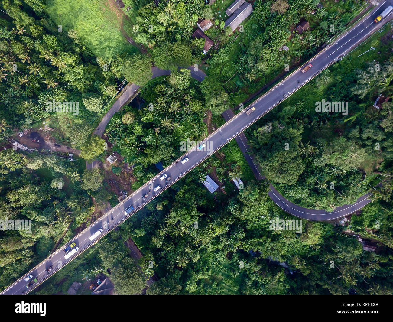 Nuova autostrada (sopra) sostituire la vecchia strada curva (bellow) in Bali Tabanan. Questa strada è parte Indonesiano della trasformazione in infrastrutture fisiche. Foto Stock