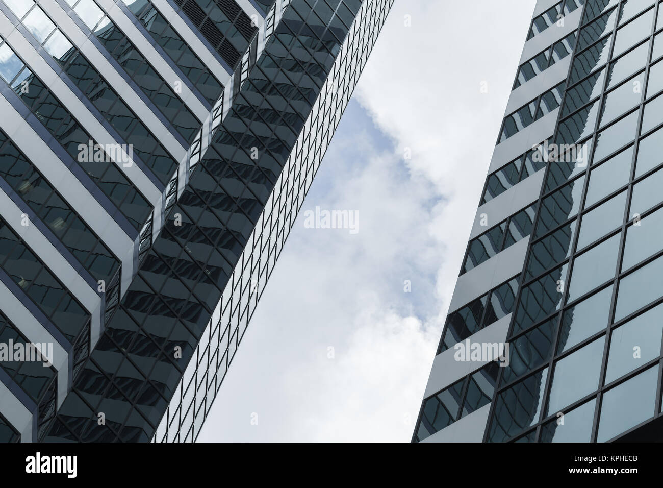 Abstract architettura moderna sfondo, ufficio torri fatta di vetro e acciaio sotto il cielo nuvoloso Foto Stock