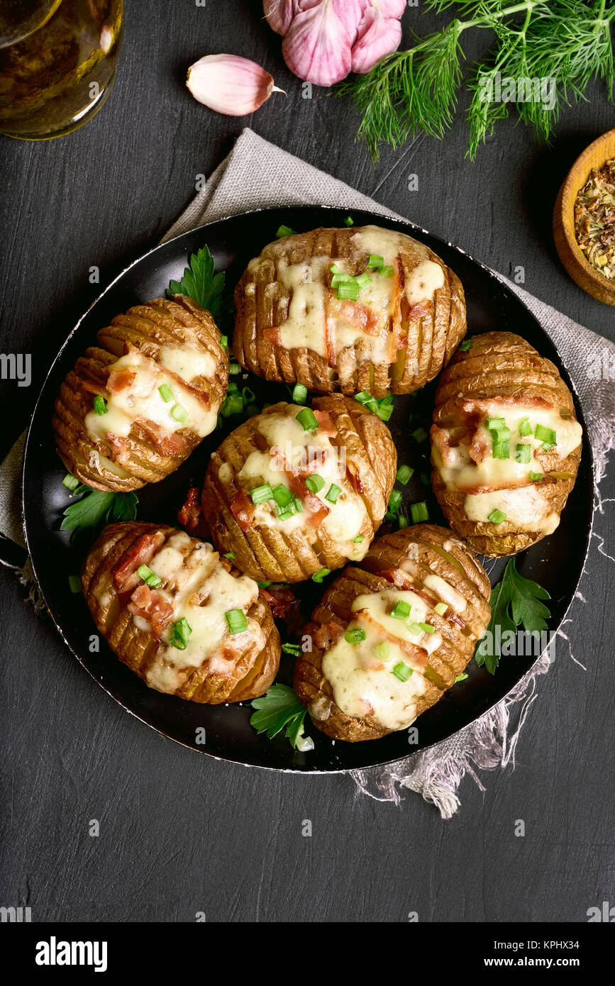 Patate al forno con pancetta, cipolla verde e formaggio. Piatto per la cena. Vista superiore, laici piatta Foto Stock