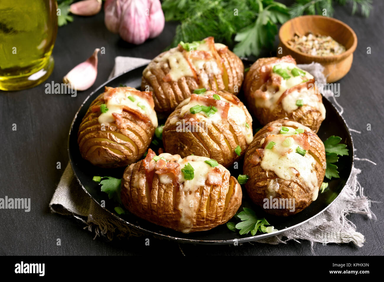 Saporite patate al forno con pancetta, cipolla verde e formaggio. Piatto per la cena. Vista ravvicinata Foto Stock