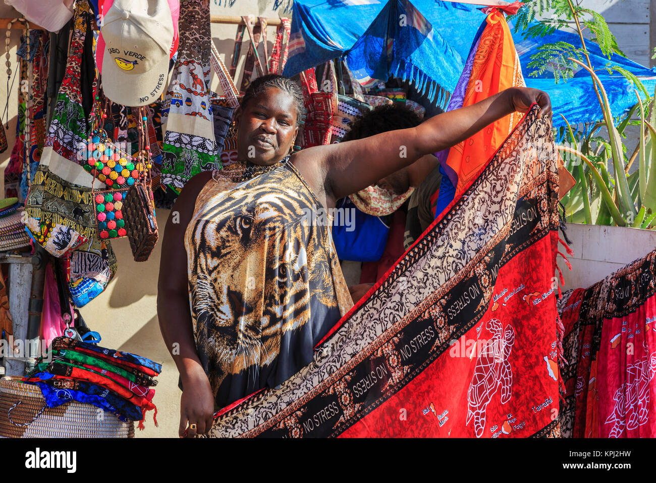 Donna locale vendita di scialli e si avvolge in una fase di stallo con souvenir turistici e abbigliamento, Santa Maria, Isola di Sal, Salina, Capo Verde, Africa Foto Stock