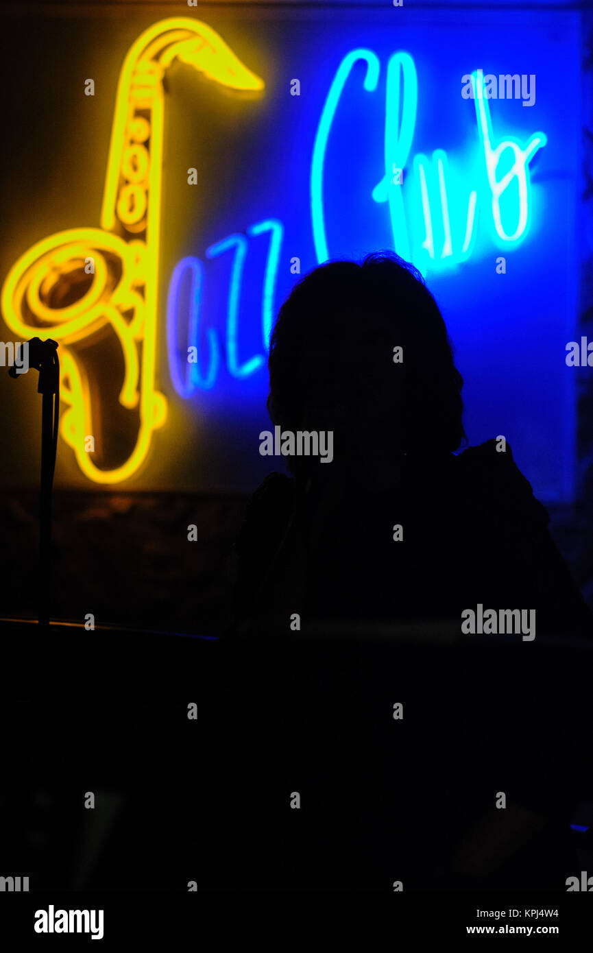 Silhouette donna matura il canto al pianoforte jazz bar. Firenze, Italia Foto Stock