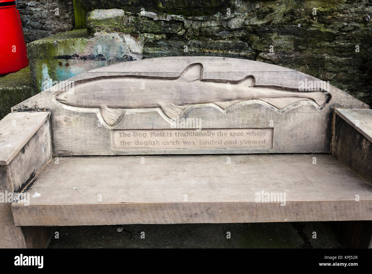 Panca scolpito che commemora il 'Dog Platt', tradizionalmente il punto in cui il gattuccio di mare catture è stato sbarcato e spellate, Mevagissey, Cornwall. Foto Stock