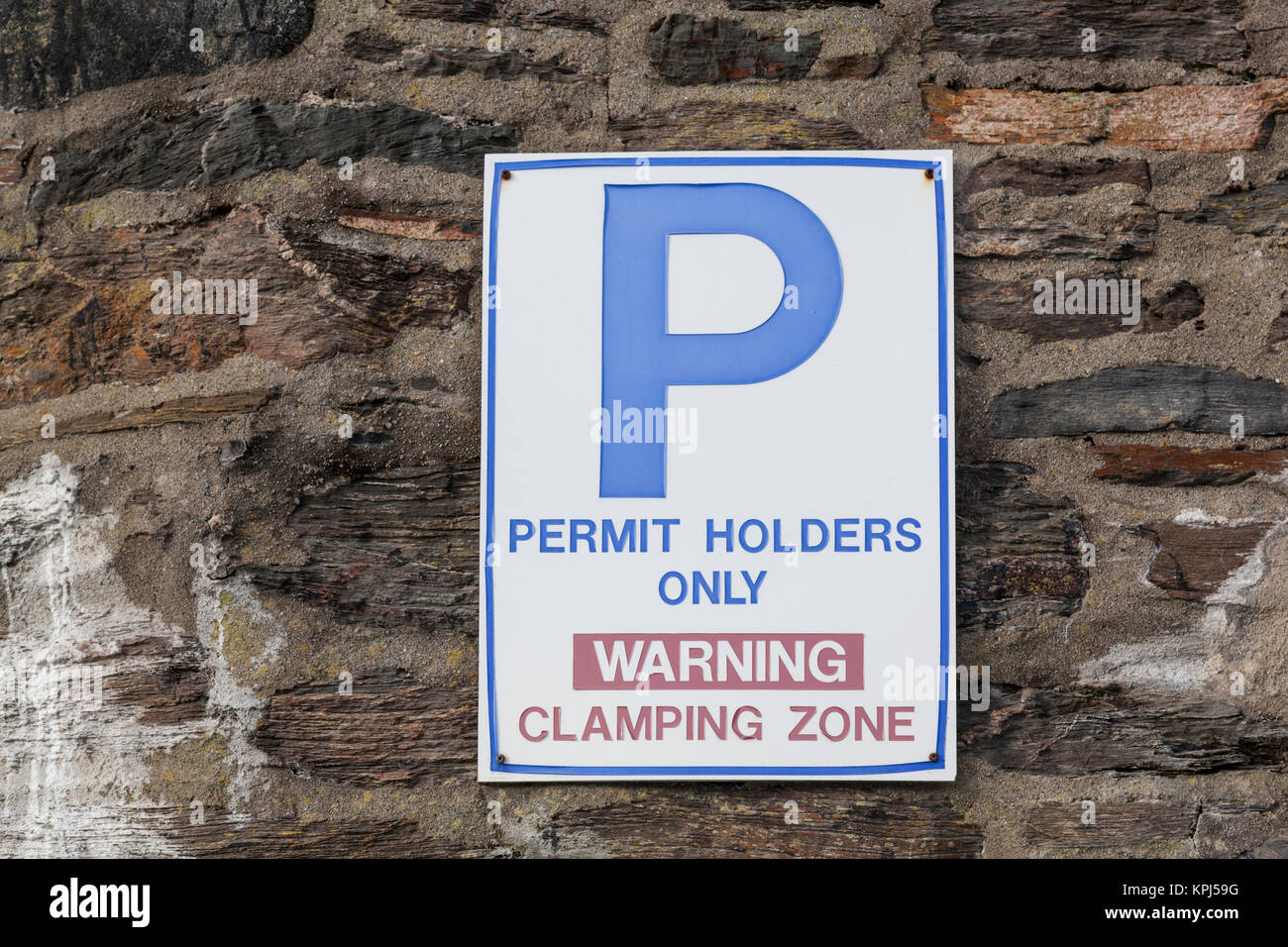 Avviso su una parete di segnalazione del bloccaggio di parcheggio zona tranne che per i titolari di autorizzazioni. Foto Stock