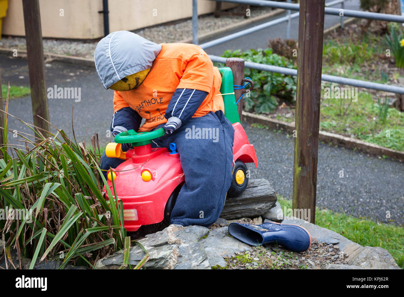 Divertimento manichino vestito come un bambino su un giocattolo auto. Foto Stock