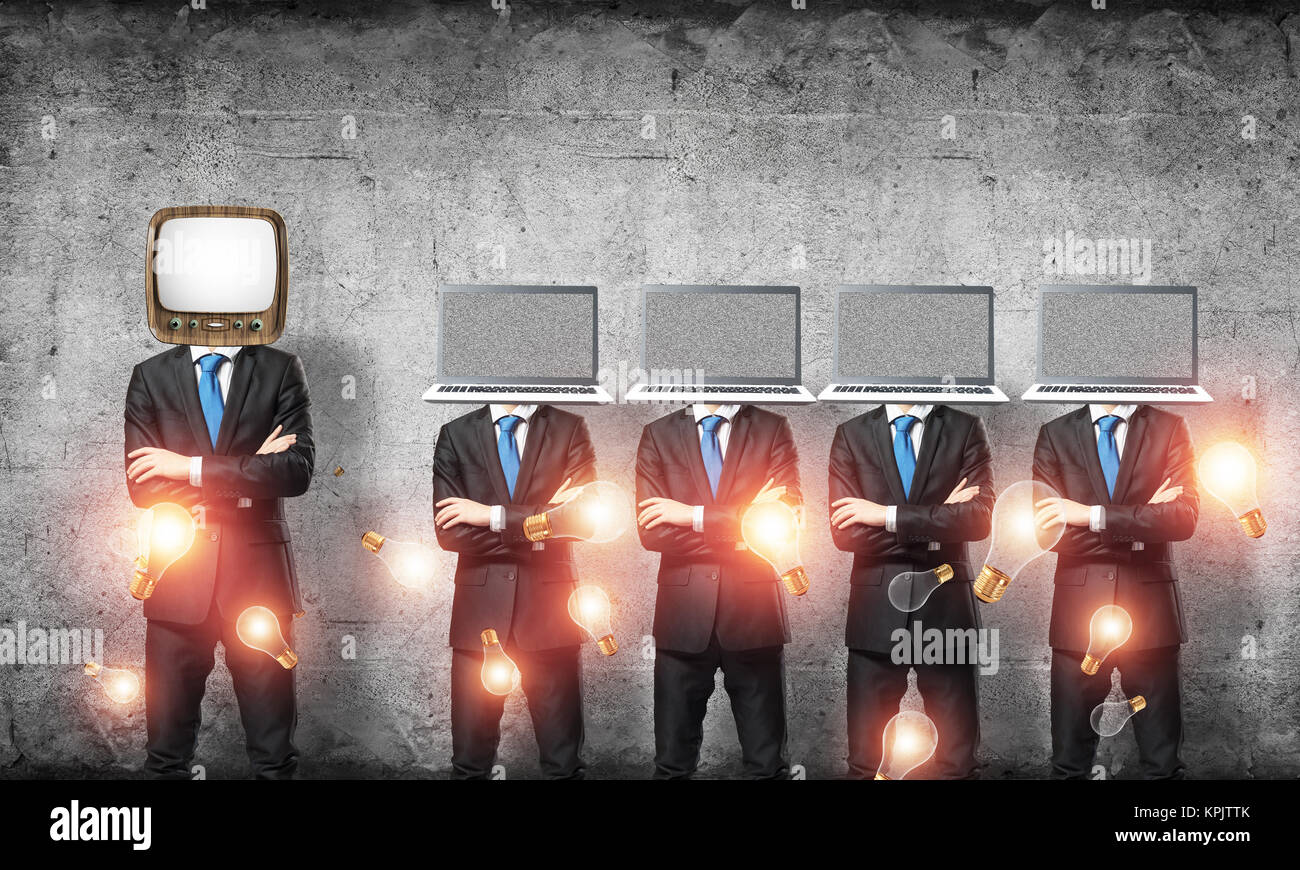 Uomini d'affari in giacca con i laptop invece dei loro capi mantenendo le braccia incrociate mentre sta in piedi in una riga e uno in testa con il vecchio TV in stanza vuota ag Foto Stock