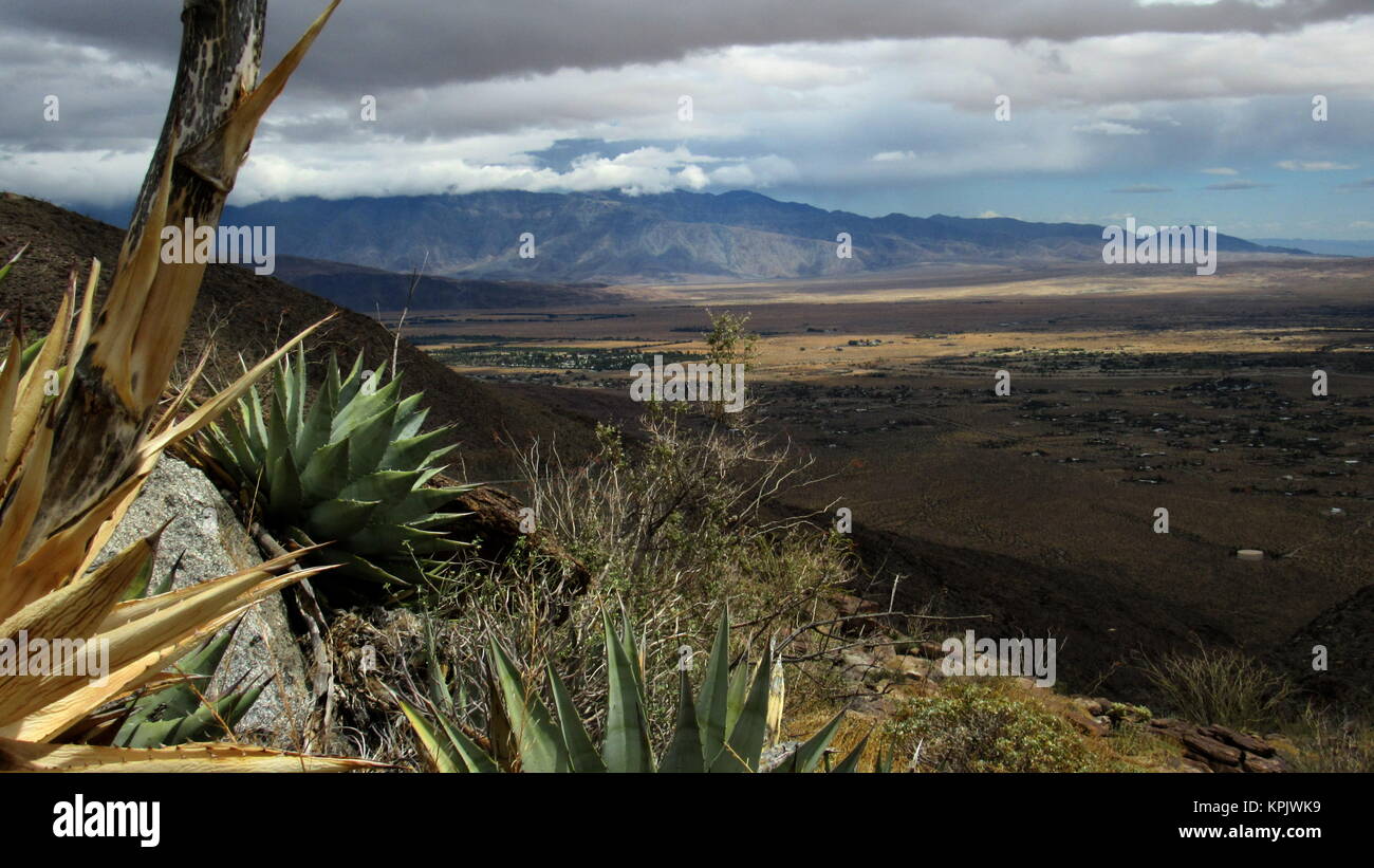 Nuvole scure di deriva e di disperdersi nel deserto valle sottostante mostra la gamma della montagna di background Borrego valley Foto Stock