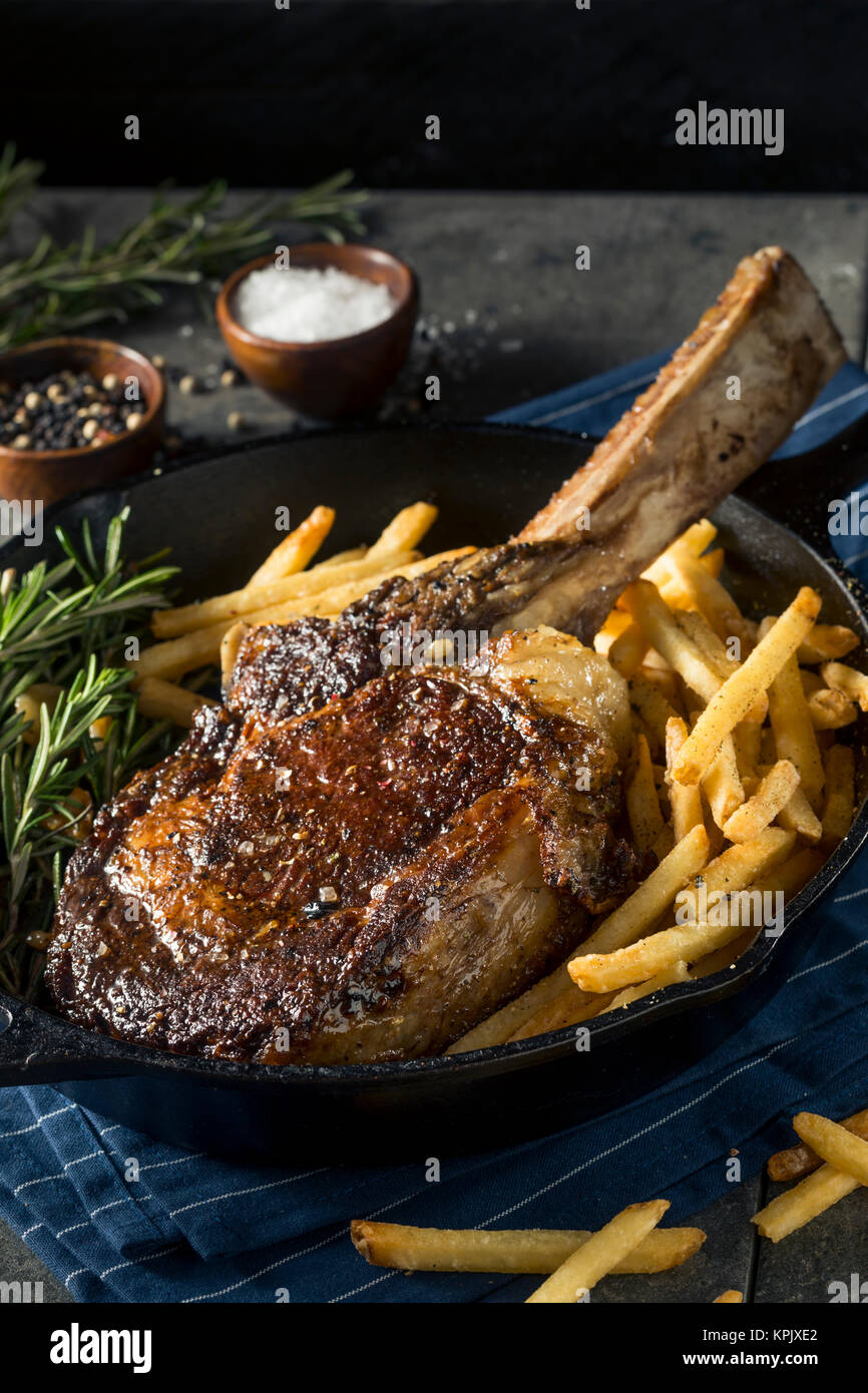Erba cotta alimentato Tomahawk bistecche con patatine fritte e rosmarino Foto Stock