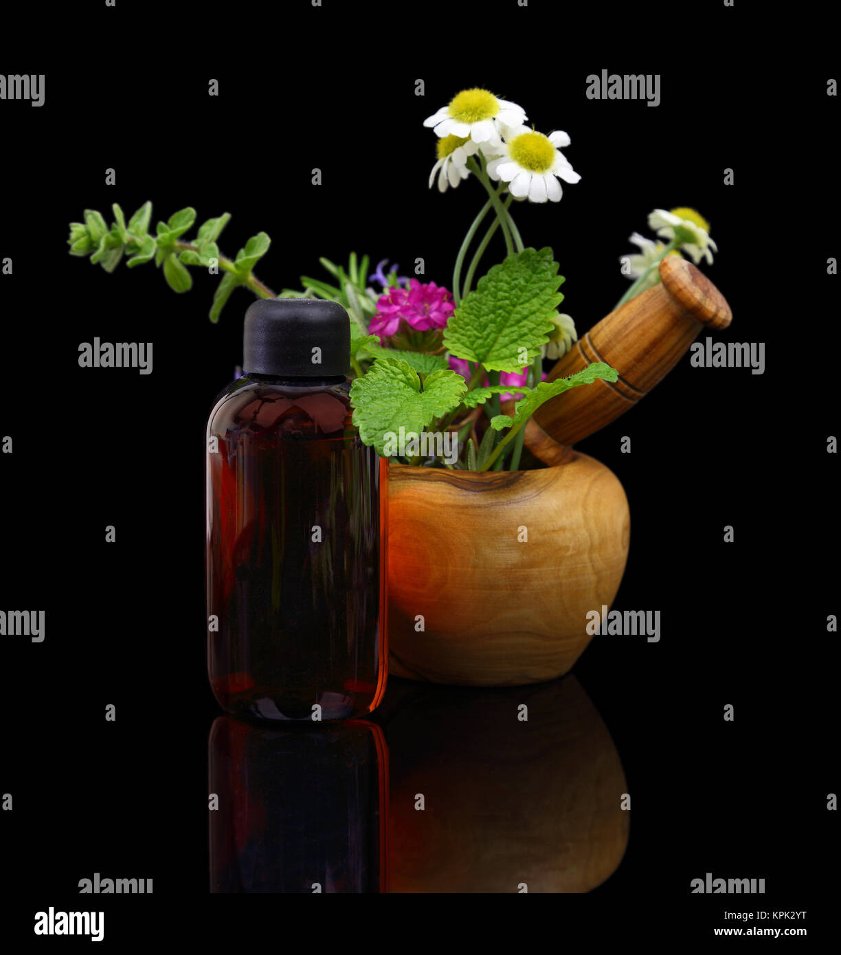Mortaio e pestello con erbe fresche ed essenziali di bottiglia di olio Foto Stock