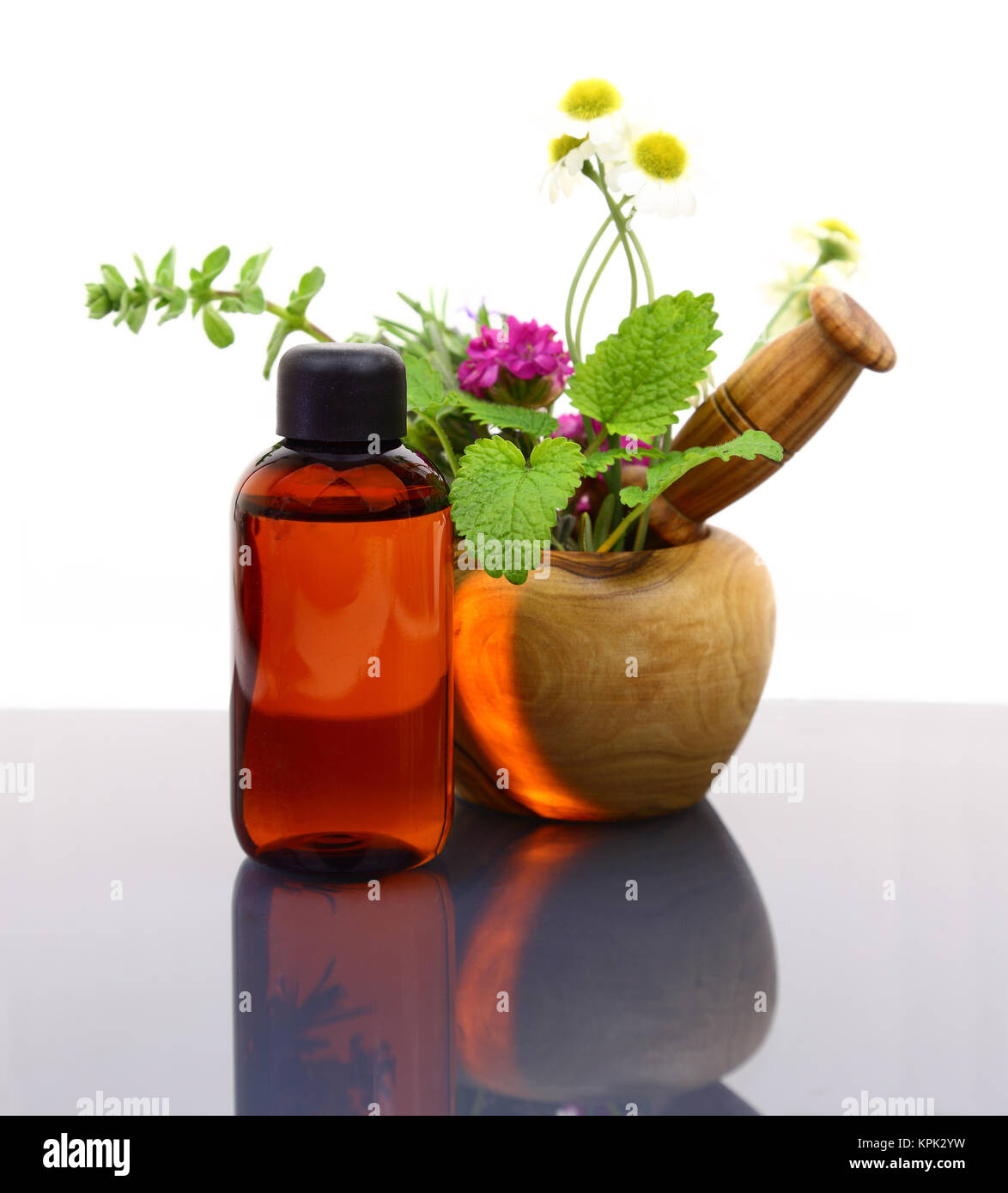 Mortaio e pestello con erbe fresche ed essenziali di bottiglia di olio Foto Stock