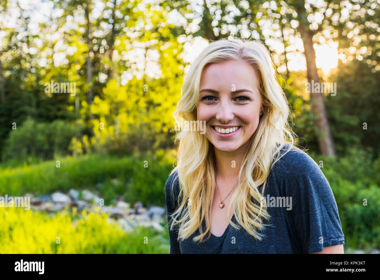 Ritratto di una giovane donna con capelli lunghi biondi in un parco in autunno; Edmonton, Alberta, Canada Foto Stock