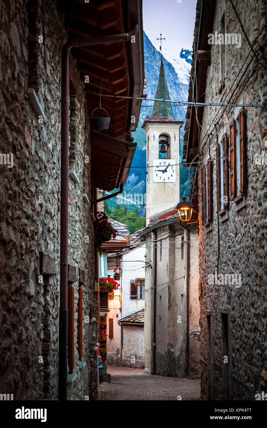 Antiche strade lastricate portano a una chiesa, Dolonne, vicino a Courmayeur; Valle d'Aosta, Italia Foto Stock