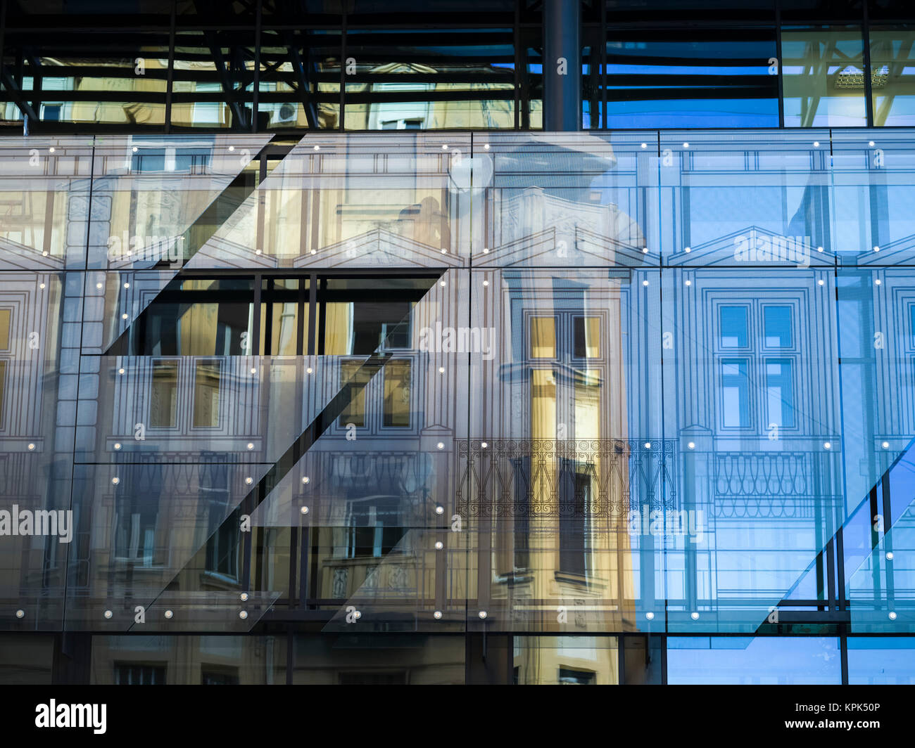 Facciata di un edificio visto attraverso pannelli di vetro con riflessioni di giallo e blu; Belgrado e Vojvodina, Serbia Foto Stock